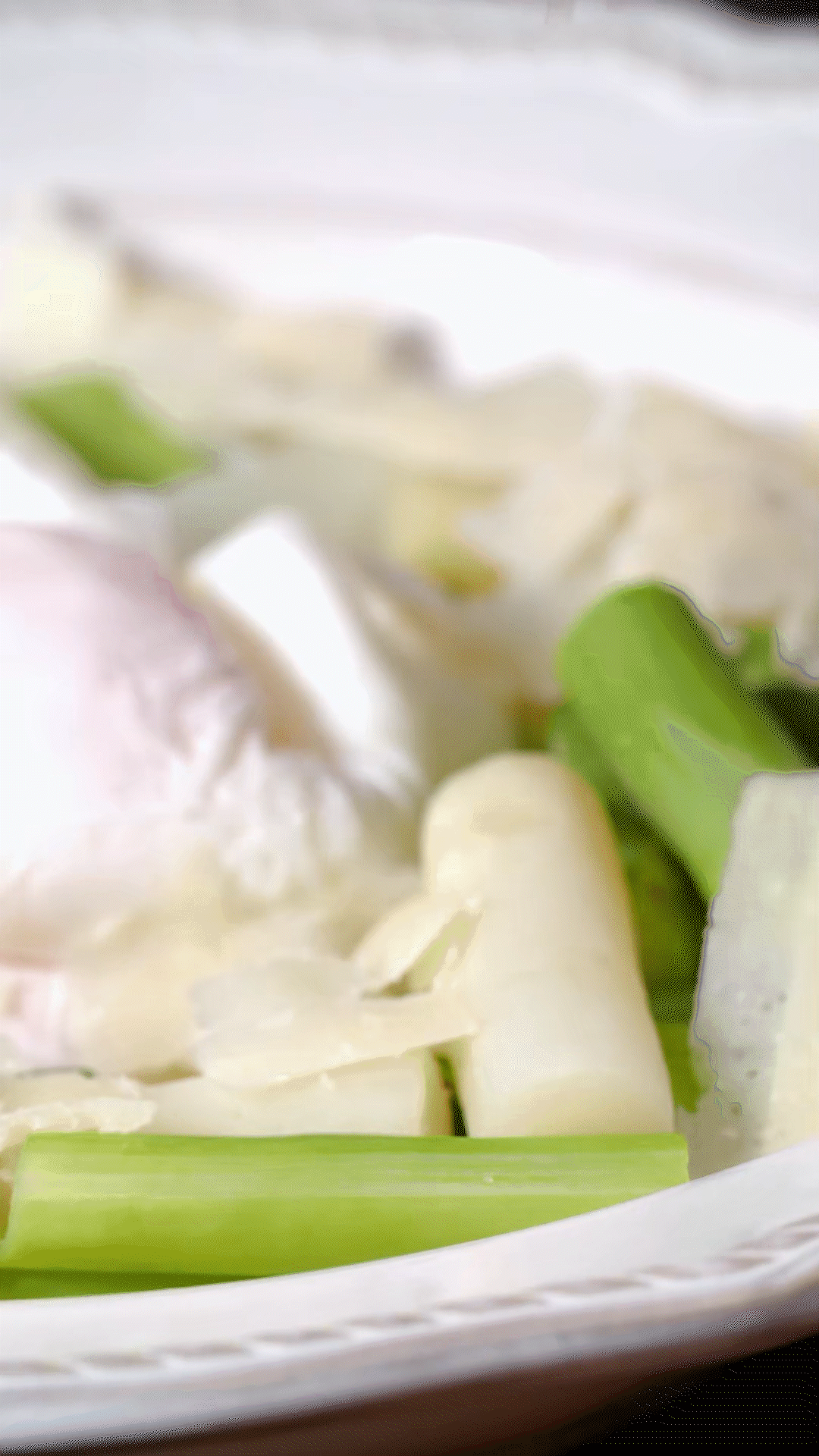 盘中放上芦笋和鸡蛋后，刨上适量干酪
